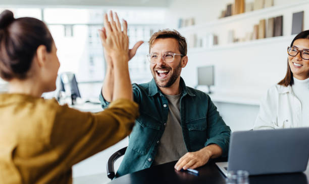 Diverse group of happy business professionals celebrating success together